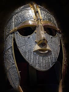 This replica is of a warrior mask, excavated ship at the burial mound of Sutton Hoo, features elaborate details of battle scenes are imprinted on the mask.