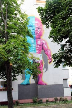 New York-based artist Ron English brought his candy-colored Pop-Surrealist aesthetic to the streets of Germany with this “freaky” 2018 mural.