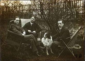 This 1914 photograph shows the Duchamp brothers, (from left to right) Marcel Duchamp, Jacques Villon, and Raymond Duchamp-Villon with Jacques Villon’s dog Pipe in the garden of Jacques’ Puteaux studio.