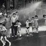 Children playing in water sprayed from open fire hydrant, Lower East Side, New York (1942)